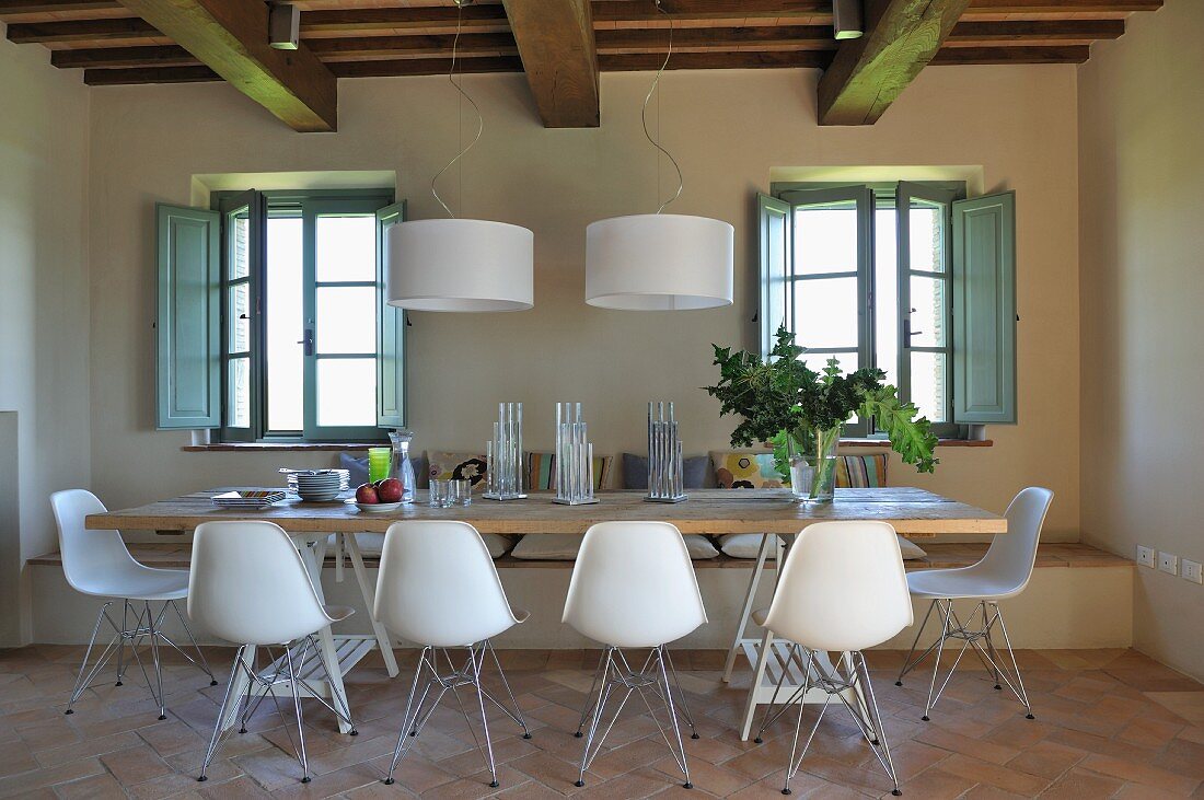 Essplatz mit weißen Schalenstühlen und Designer Hängelampen im renovierten Landhaus