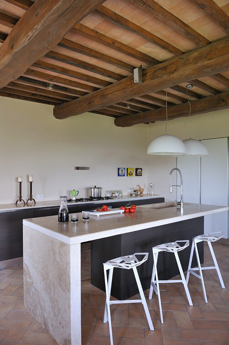 Zeitgenössische Küchentheke mit Designer Barhockern in offener Küche eines renovierten Landhauses