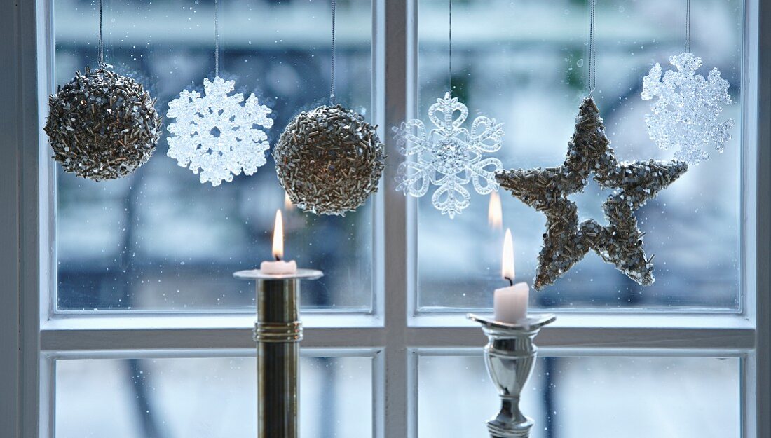 Christmas decorations and candles at a window