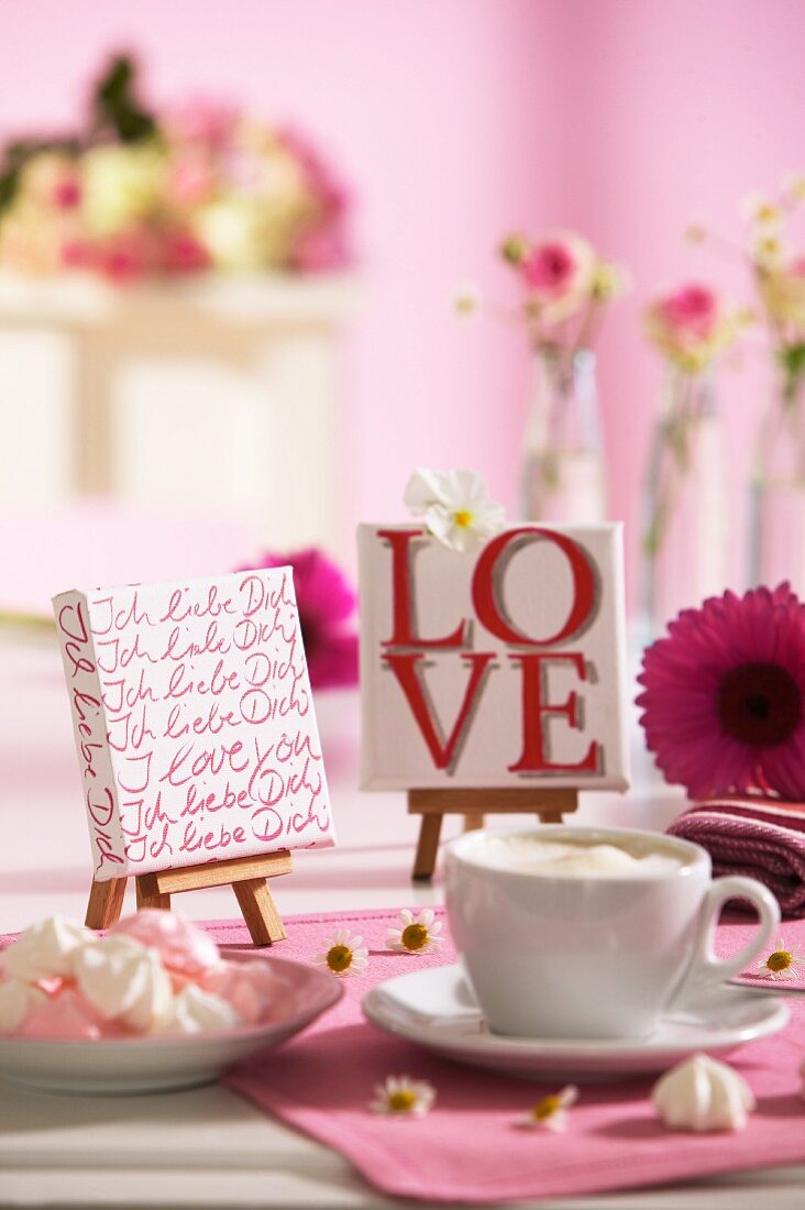 Tasse Kaffee auf liebevoll dekoriertem Tisch zum Valentinstag