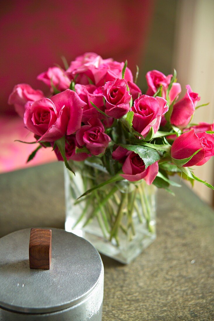 Bouquet of pink roses in glass vase and ceramic box with lid