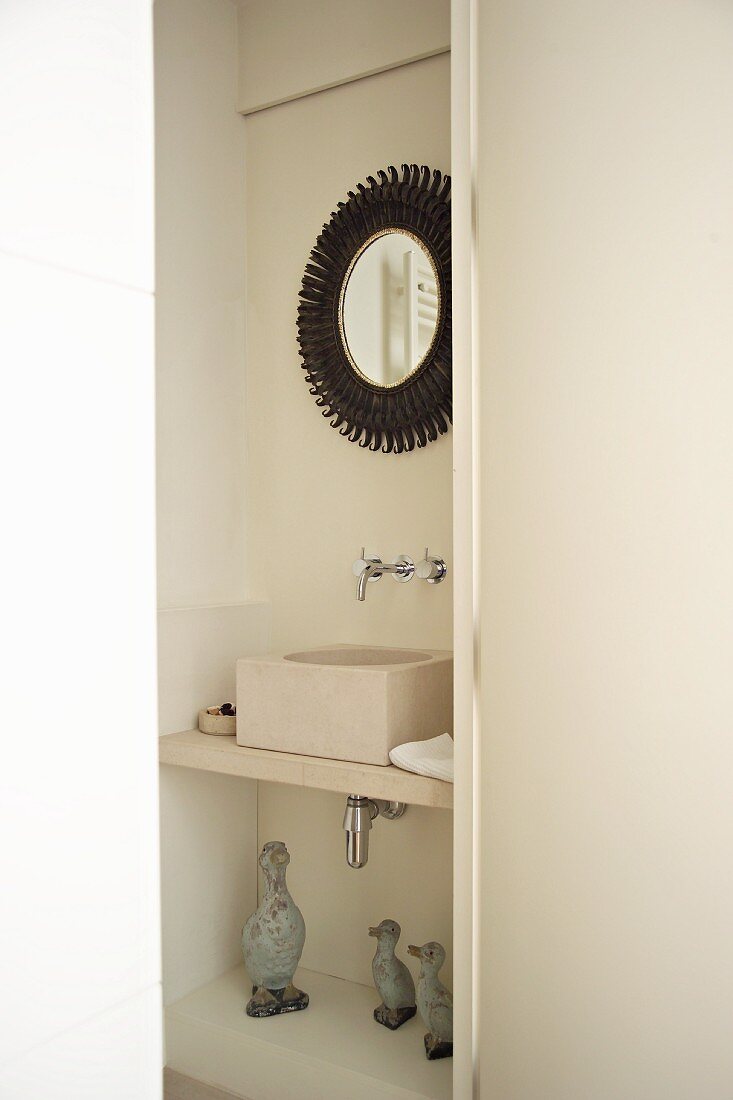 Nische mit modernem Waschbecken und gerahmtem Spiegel in Bad
