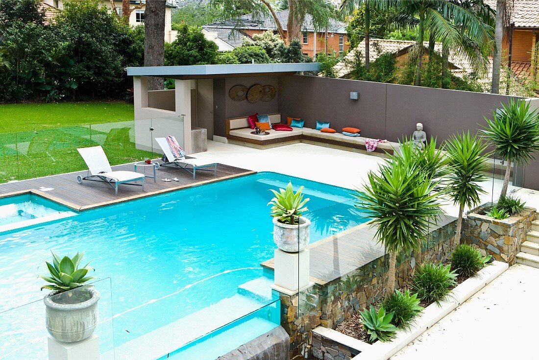 Modern pool area with palms and terrace with patio furniture