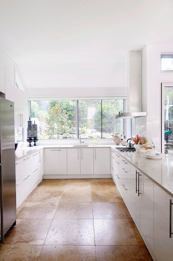 Designerküche in Weiß mit hellbraunen grossformatigen Bodenfliesen