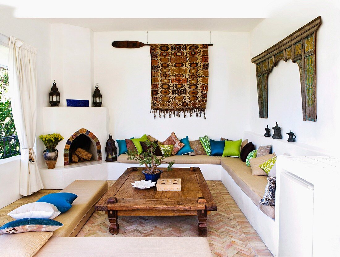 Moroccan-Greek elements in a living room with a masonry fireplace and upholstered seating
