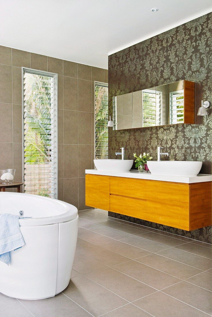 Modern bathroom with free-standing bathtub in front of floor-to-ceiling window