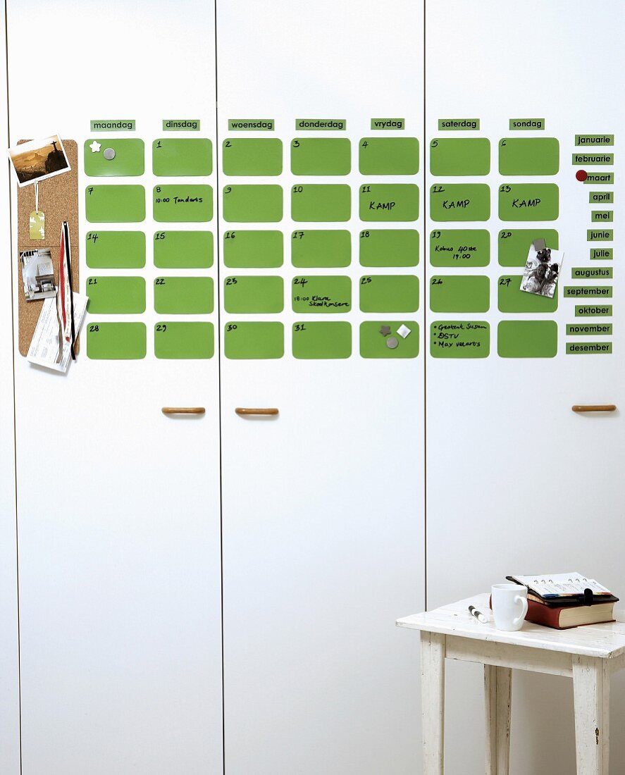 Calender made of green magnetic wafers on white cabinet fronts