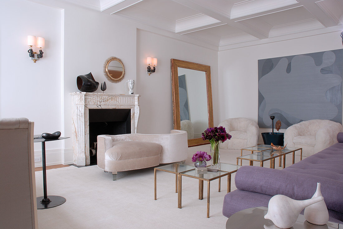 Feminines, elegantes Wohnzimmer in Weiß und Malve mit goldgerahmten Spiegeln und Glastischen mit Messinggestellen