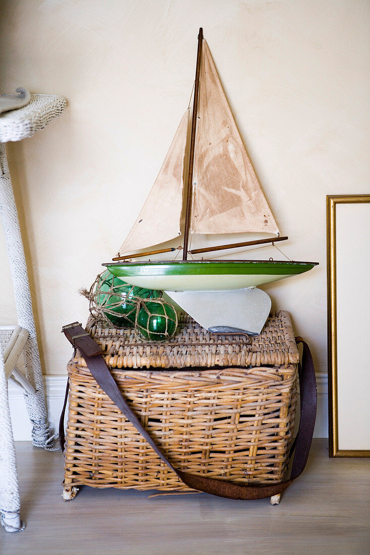 Basket with lid and old model ship on the floor