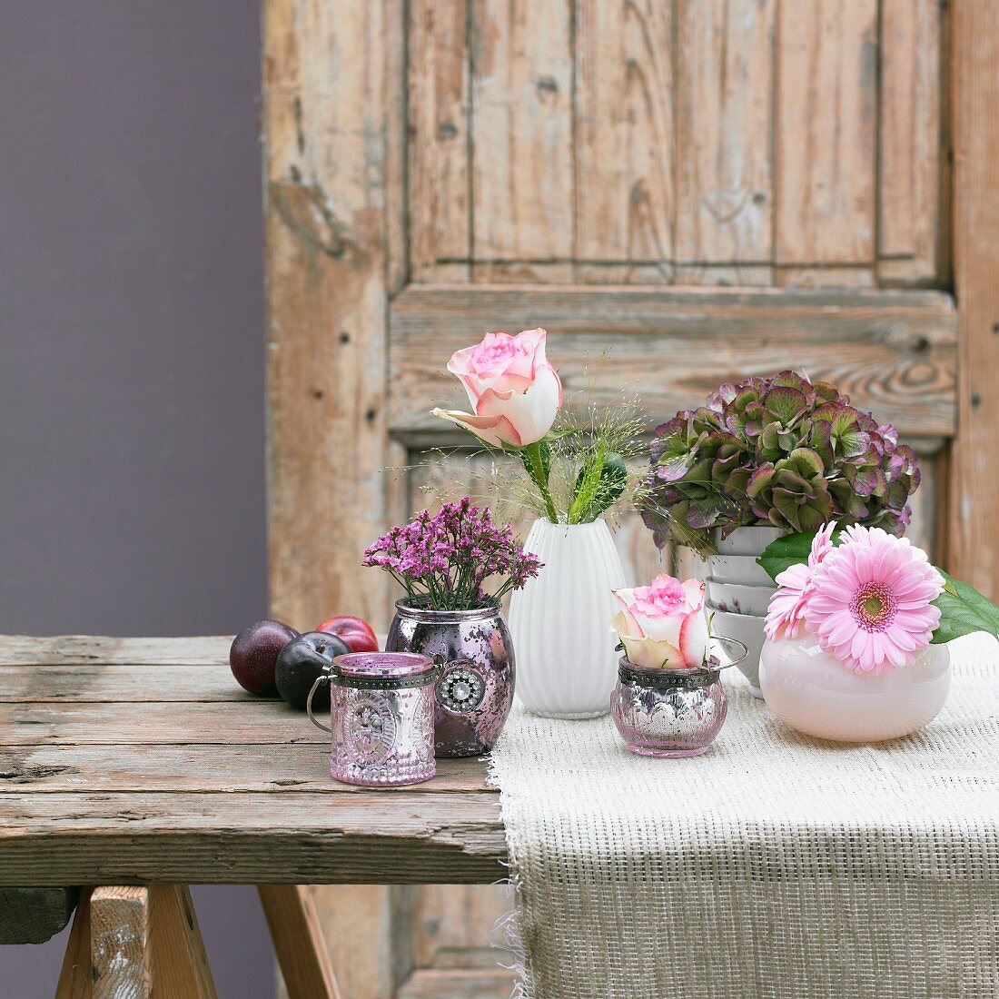 Sommerliche Tischdeko mit Blumenvasen und Pflaumen
