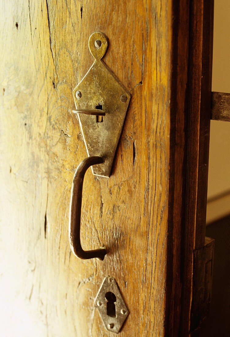 Alter Türbeschlag mit Schlossrosette und Griff aus Metall an Holztür