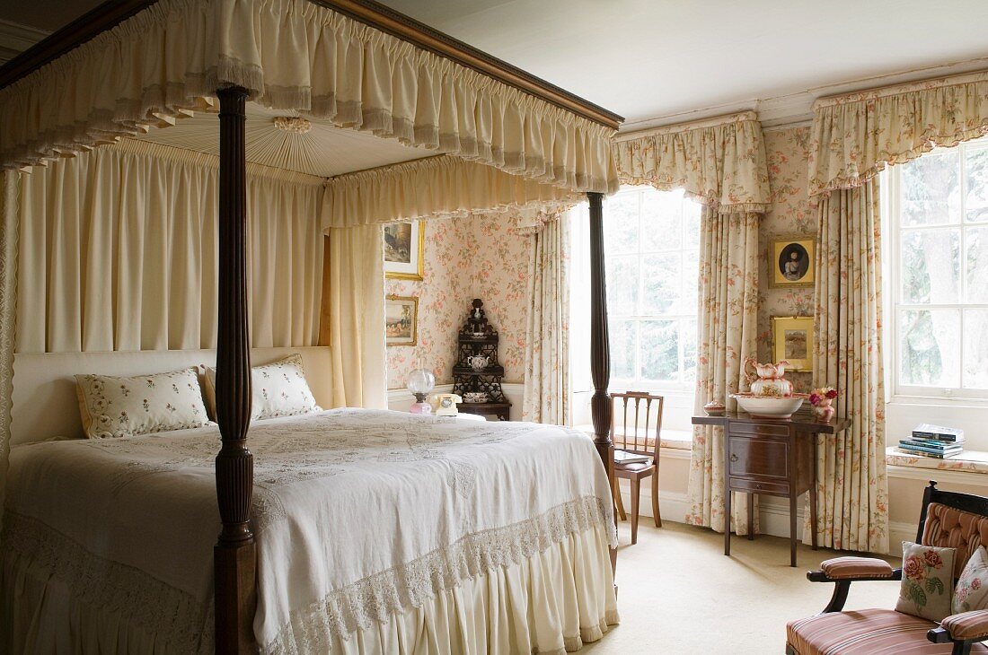 Schlafzimmer im alten, englischen Stil mit üppiger Textilausstattung für Baldachin und Vorhänge