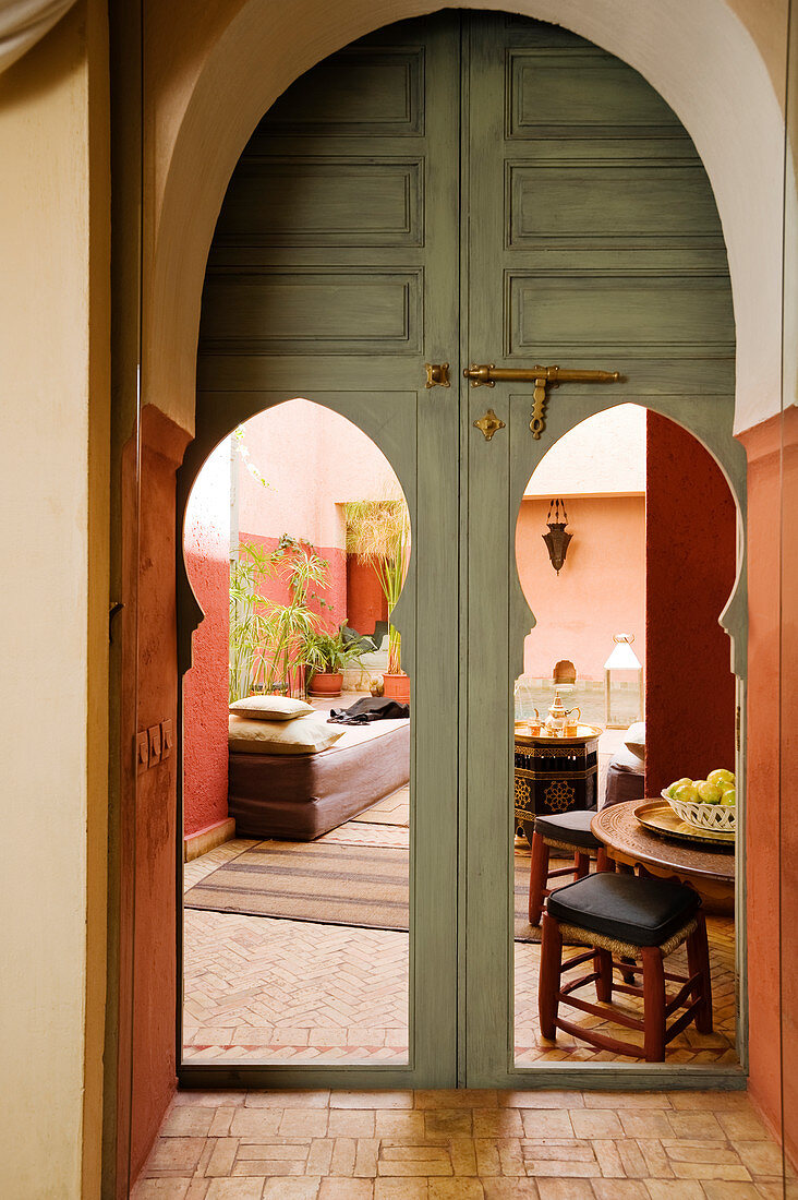 Blick durch offene Türen mit Spitzbogen in marokkanisches Wohnzimmer