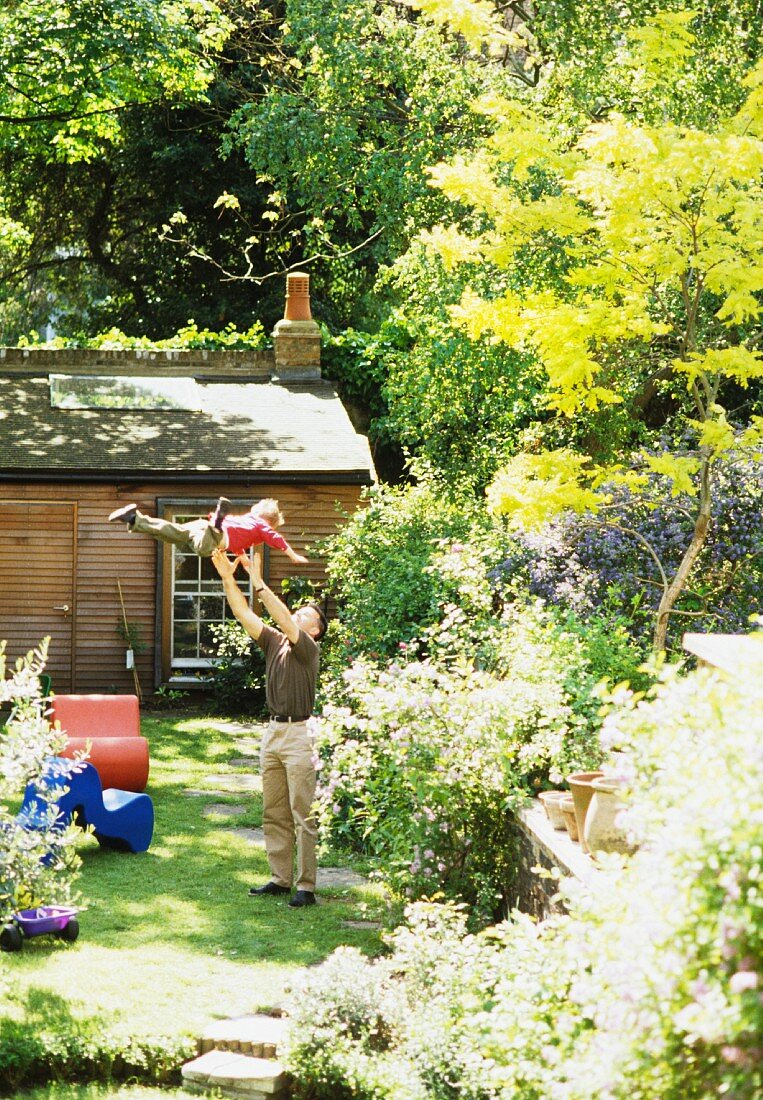 Vater spielt mit seinem kleinen Sohn im Garten