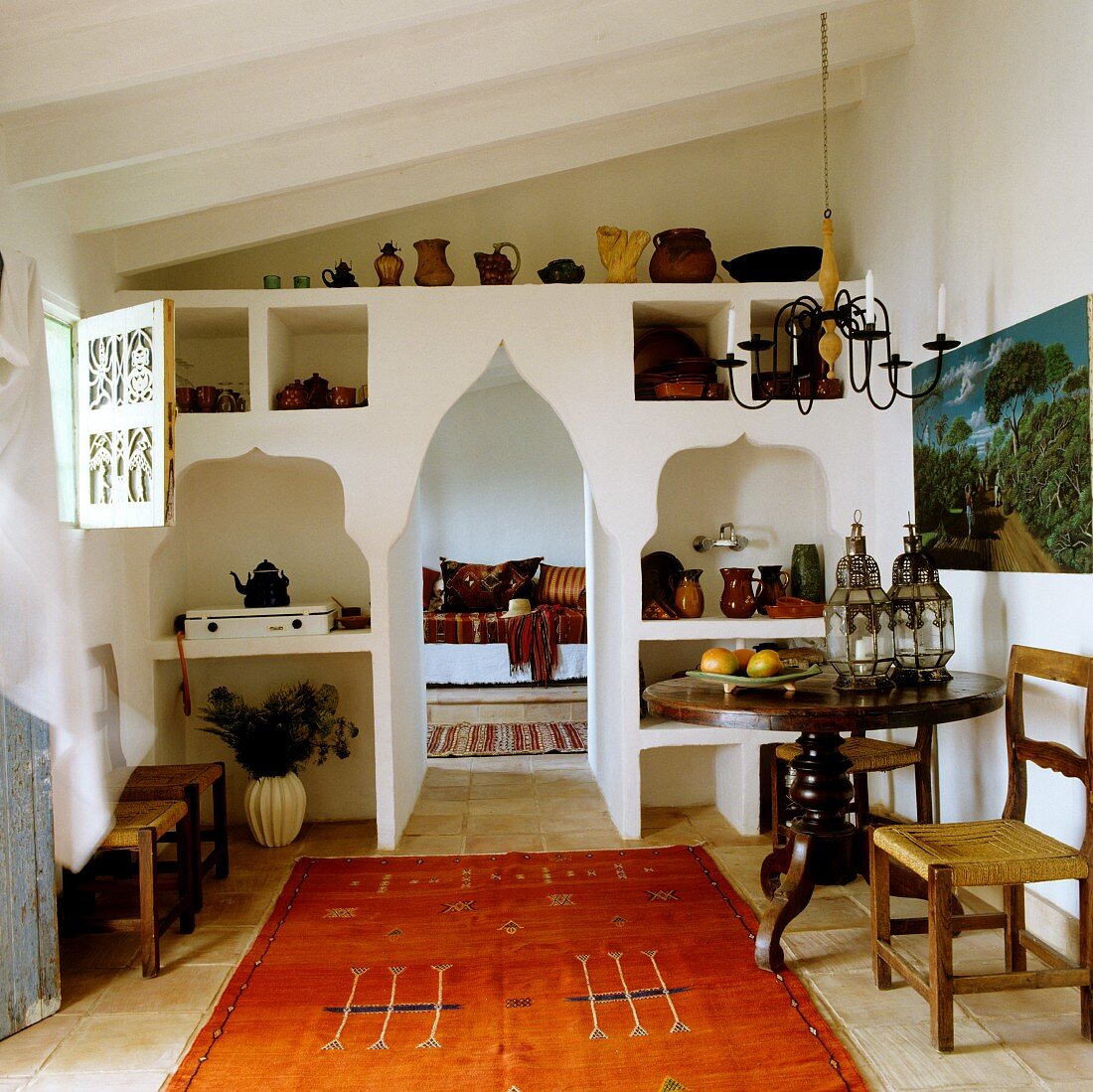 Ethnic rug in Mediterranean interior with pointed arched doorway