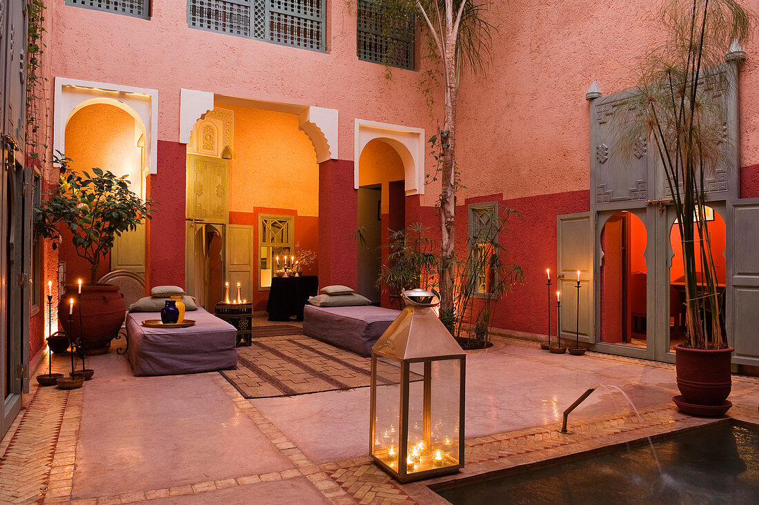 Kerzenlichtstimmung in marokkanischem Innenhof mit verschiedenen Rottönen an Wand
