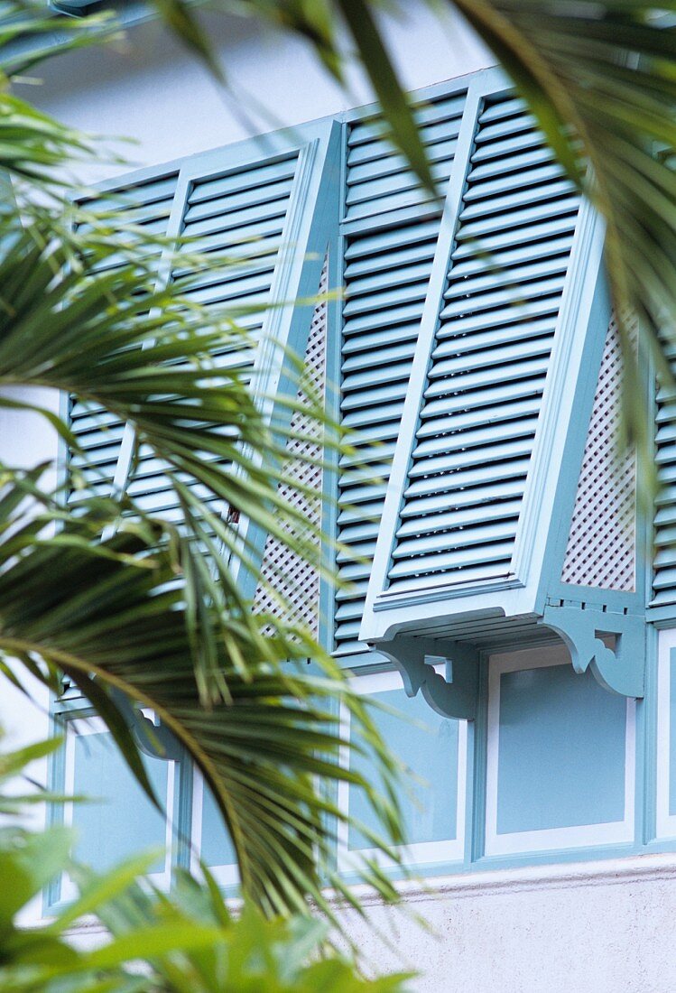 Blau lackierte Fensterläden an Fassade einer Villa in traditionellem Stil