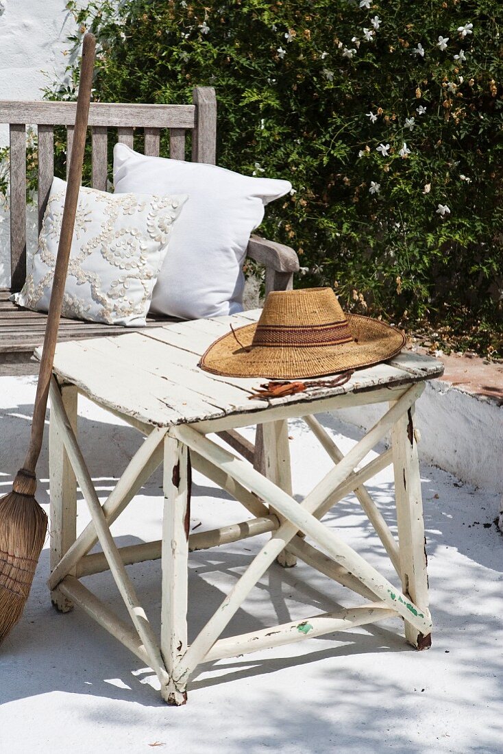Straw hat lying on weathered stool on terrace