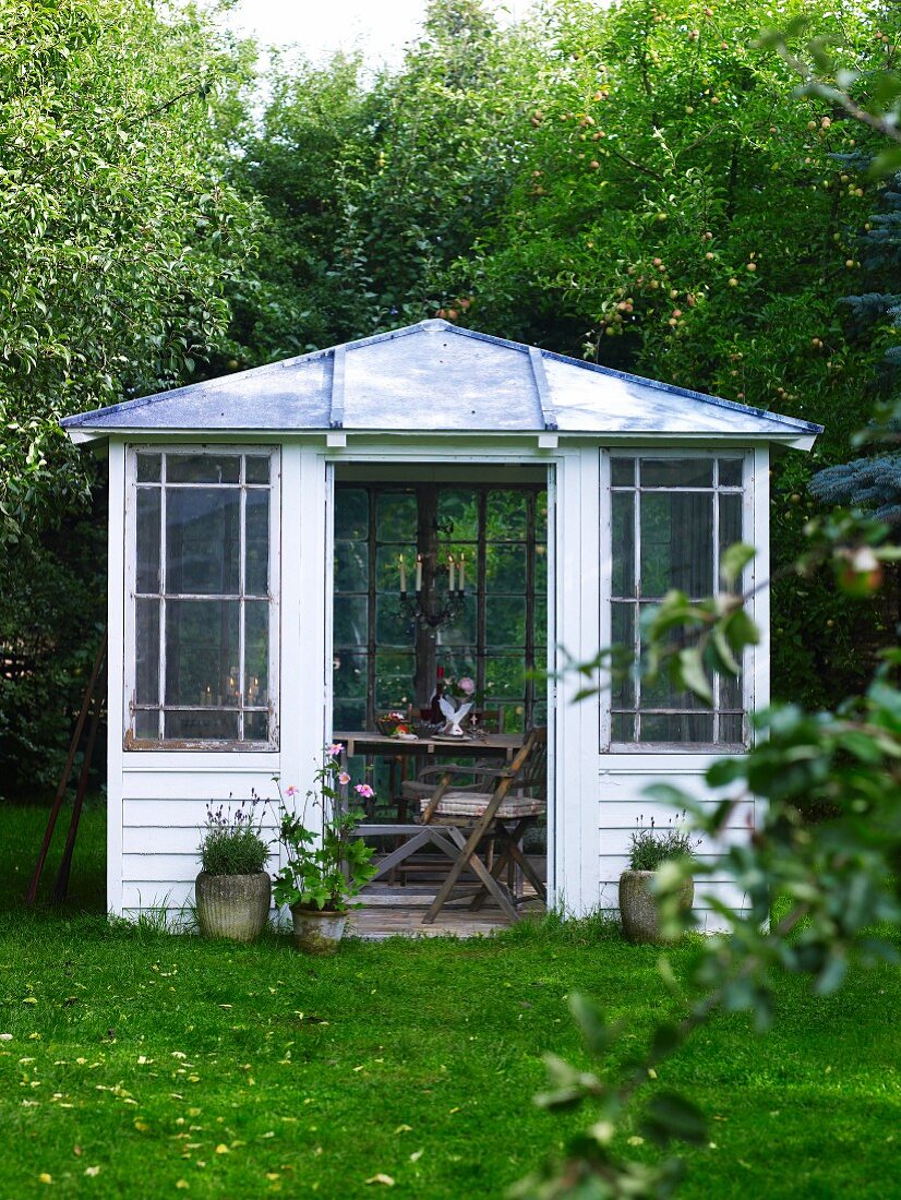 Gartenpavillon aus Holz mit Blick in stimmungsvollen Innenraum