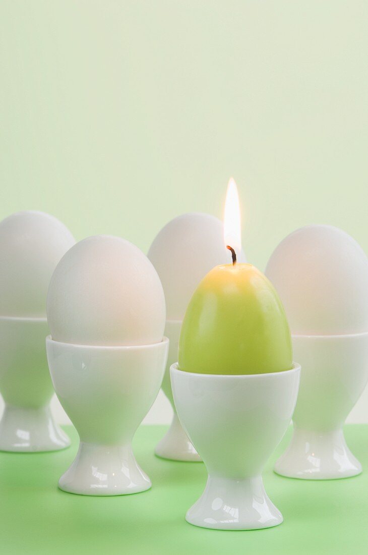 Easter eggs and egg-shaped candle in egg cups