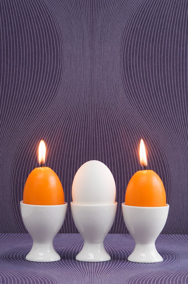 Osterei und Eierkerze in Eierbechern