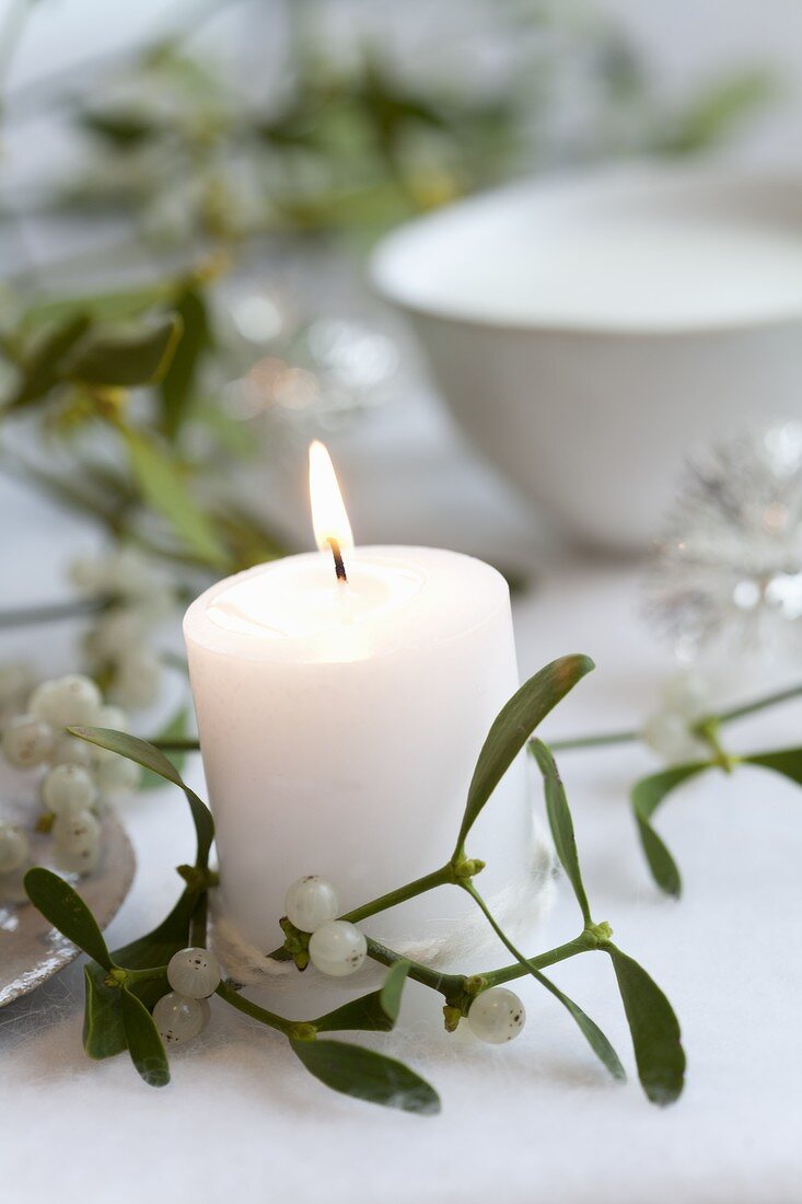 A white candle with mistletoe