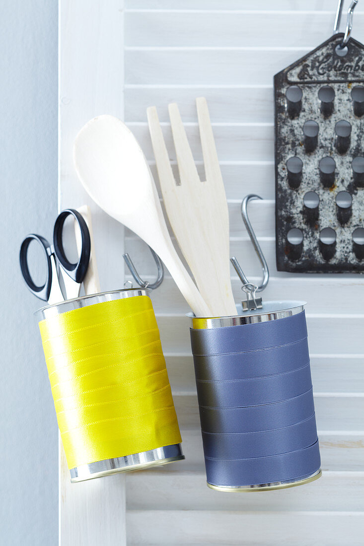 Beklebte Blechdosen dienen als Hängeaufbewahrung für Küchenutensilien