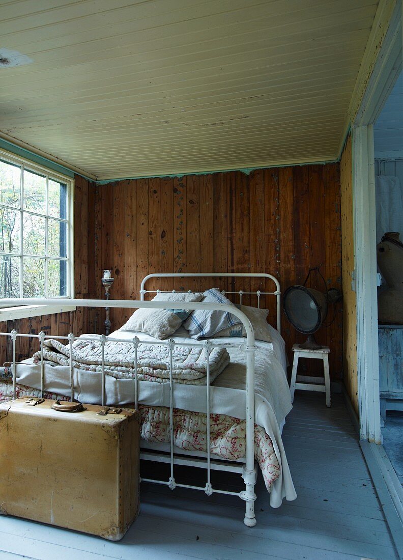 Vintage Bett mit weiss lackiertem Metallgestell in rustikalem Schlafzimmer