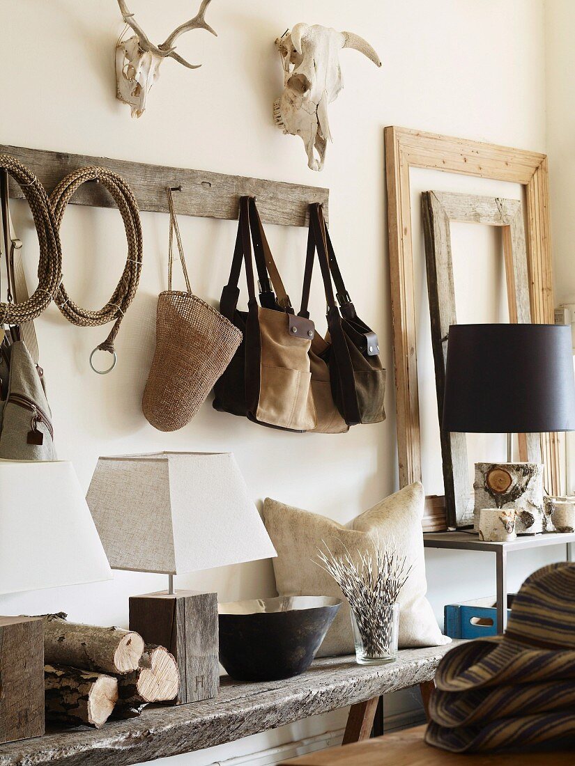 Rustic shelf and rack in corner with leather bags hanging from pegs