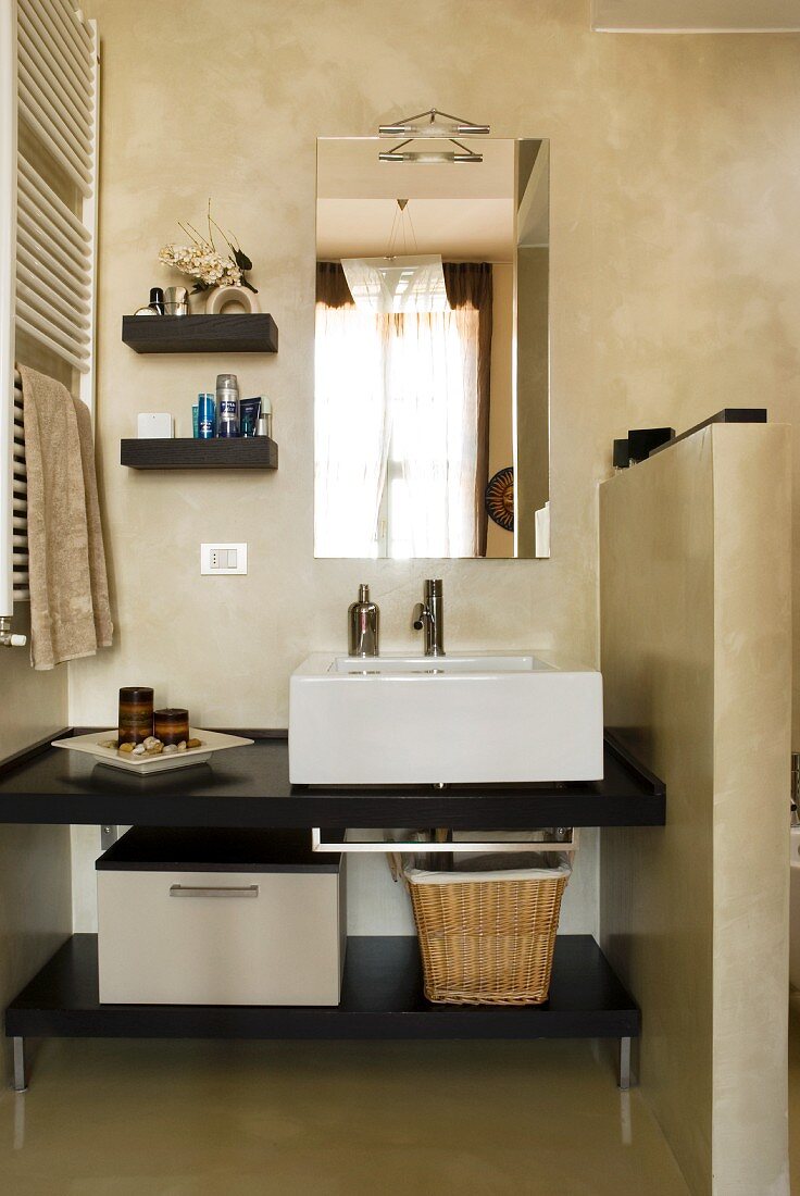 Moderner Waschtisch mit Wandspiegel neben halbhohem Raumteiler in minimalistischem Bad