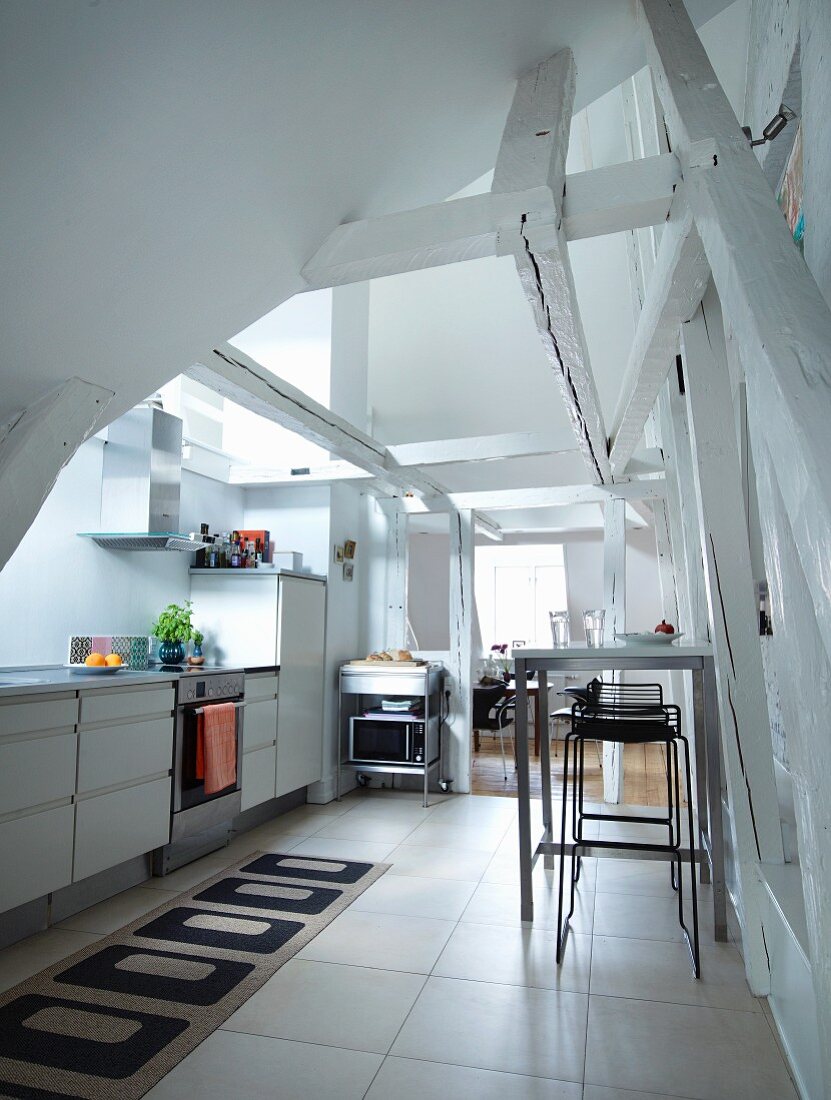 Moderne Küche unter altem Dachstuhl