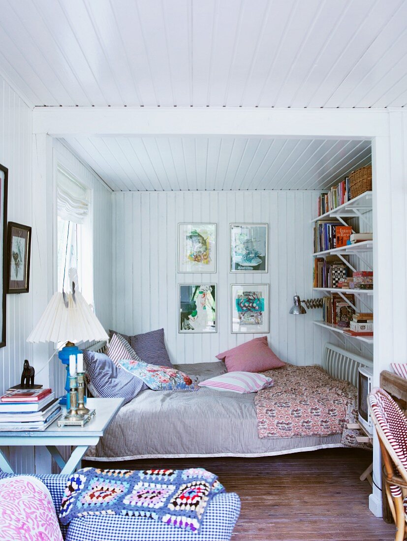 Gemütliches Schlafzimmer mit weisser Holzverkleidung an Wand und Decke