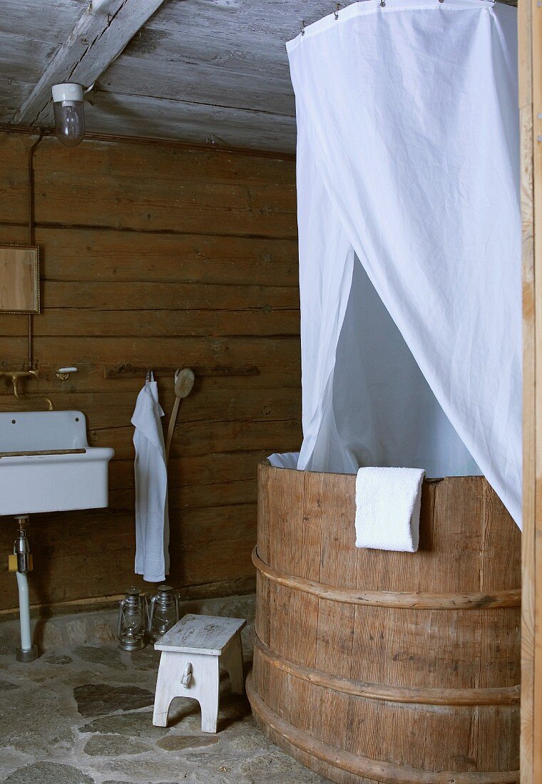 White fabric canopy over rustic tub in bathroom