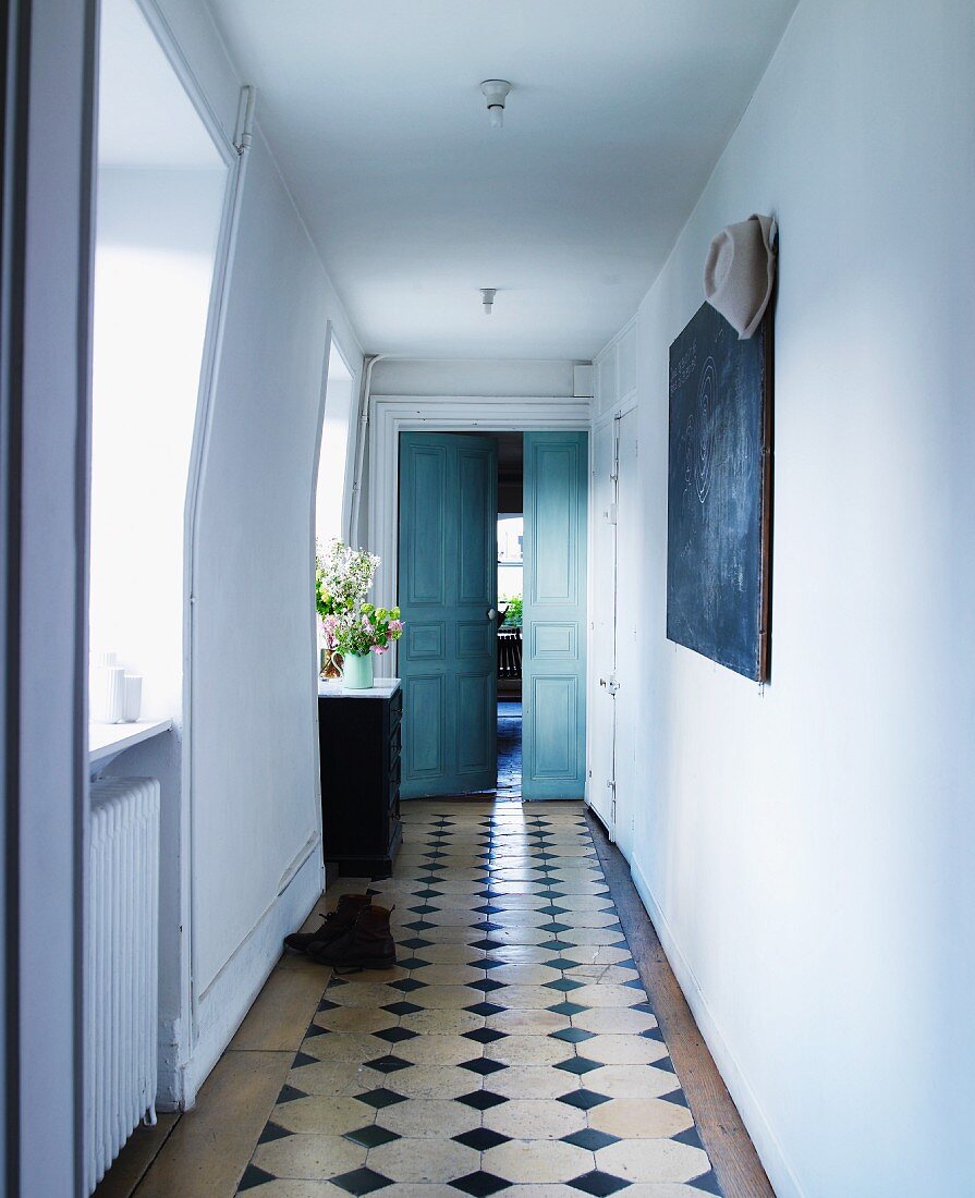 Tiled floor with black inlays in hallway of country house