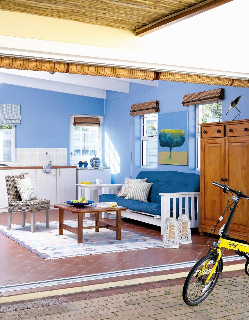 Wohnraum mit Fliesenboden & blau gestrichenen Wänden in einer umgebauten Garage