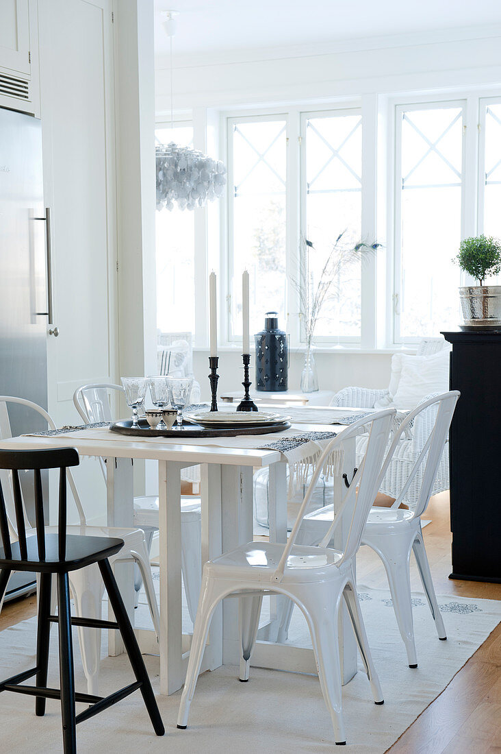 Küchentisch und weiße Metallstühle im Retrostil in offenem Wohnraum