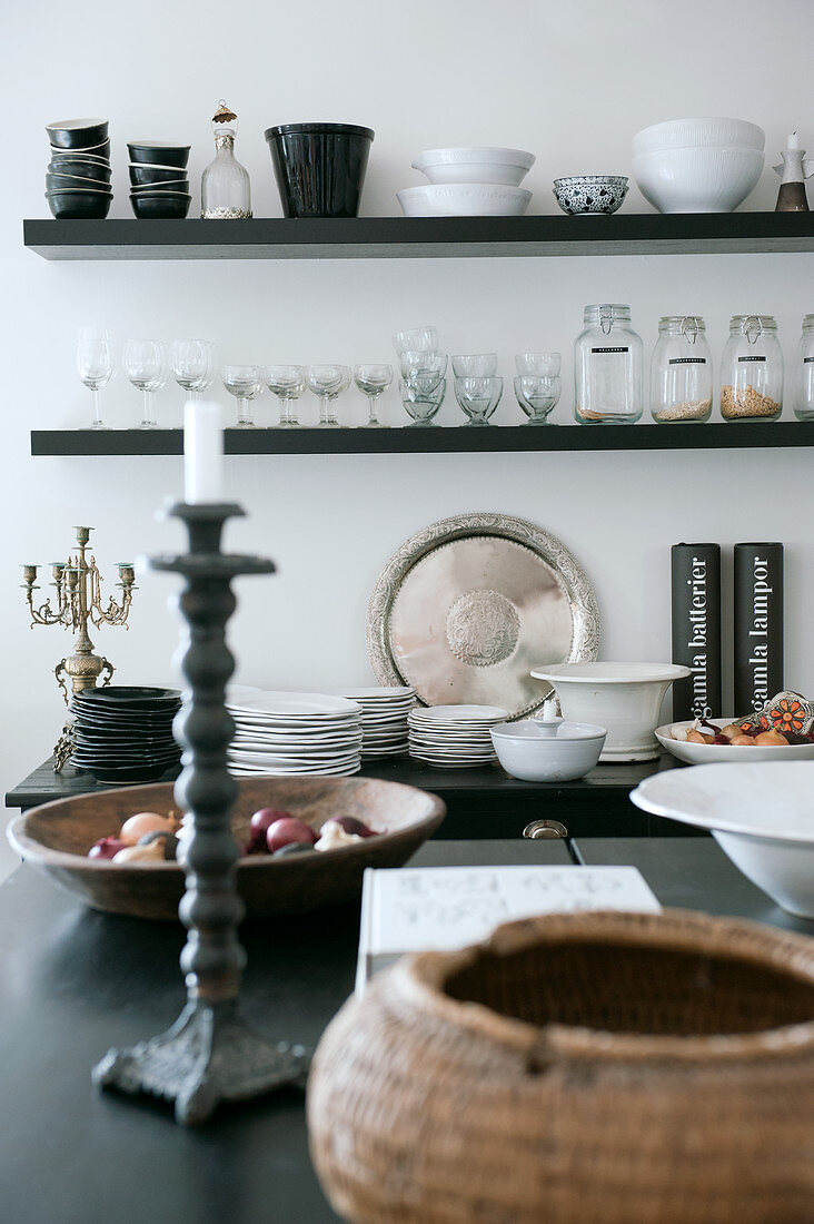 Blick über Küchentheke auf Wandborde mit antiken Flohmarkt Sammlerstücken zwischen schwarzem und weißem Geschirr