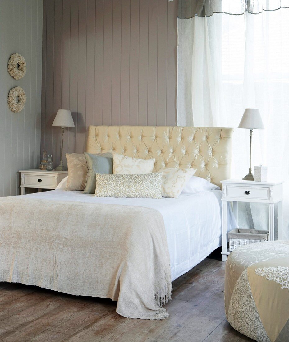 Bed with upholstered headboard in a country style bedroom