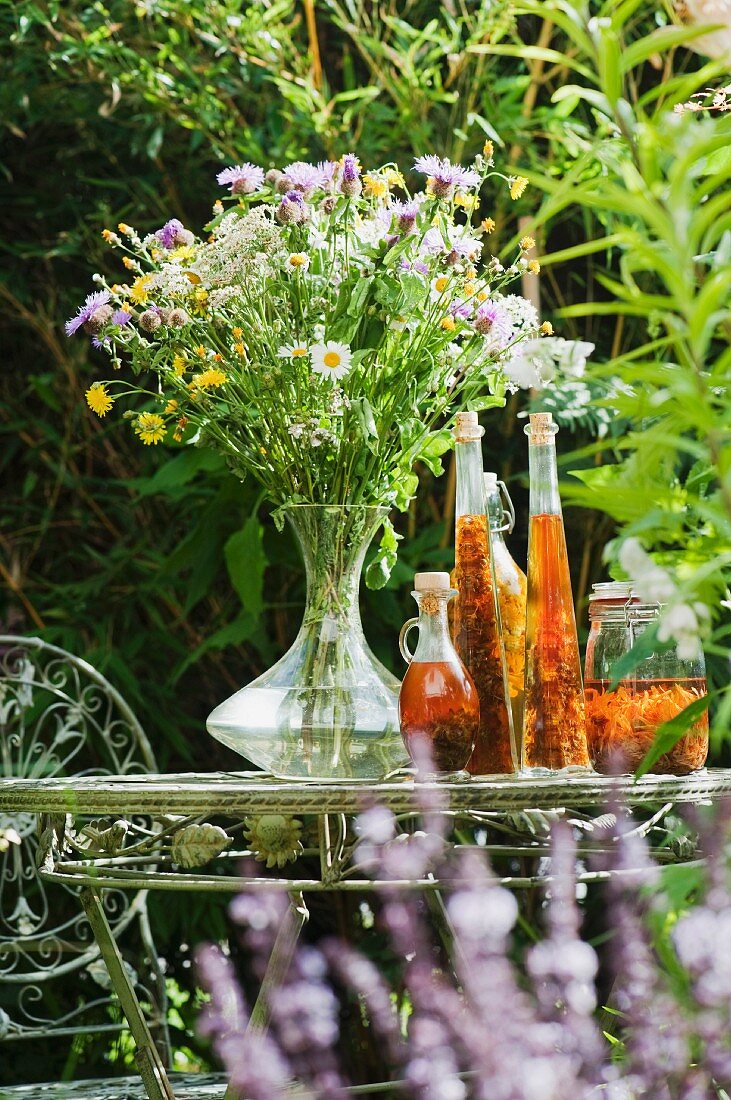 Meadow flowers and herbal essence on a garden table