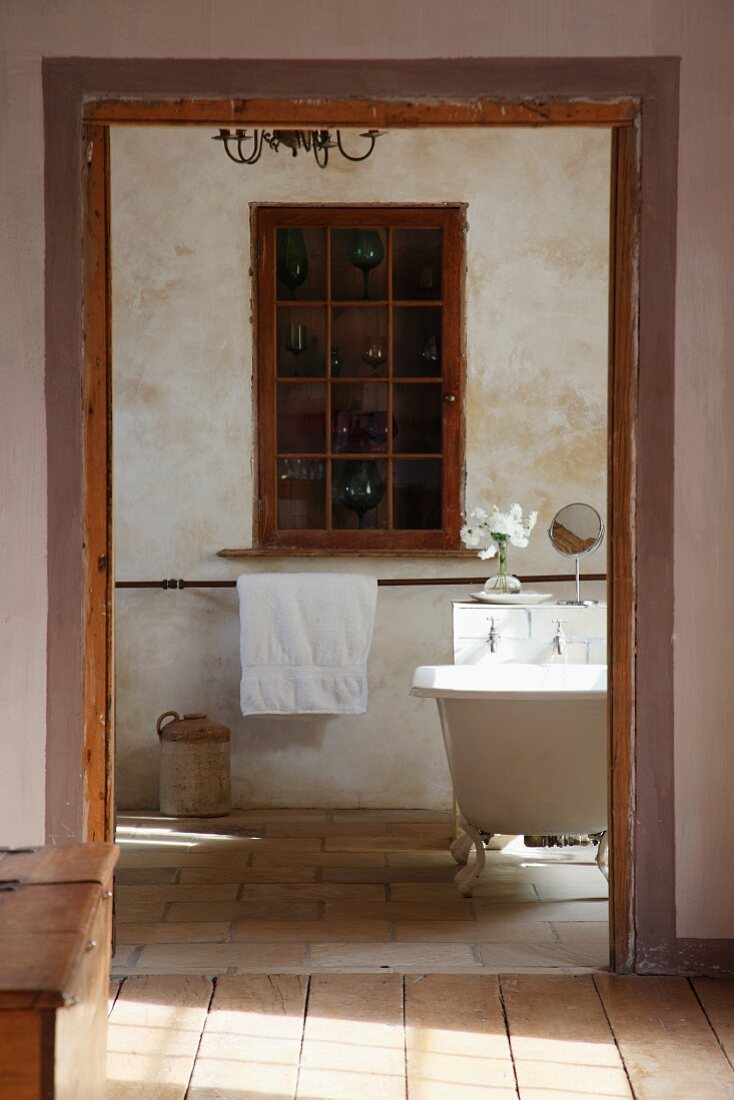 Blick vom Vorraum auf Wandnische mit eingebautem Schrank und Glas Sprossentür in rustikalem Bad