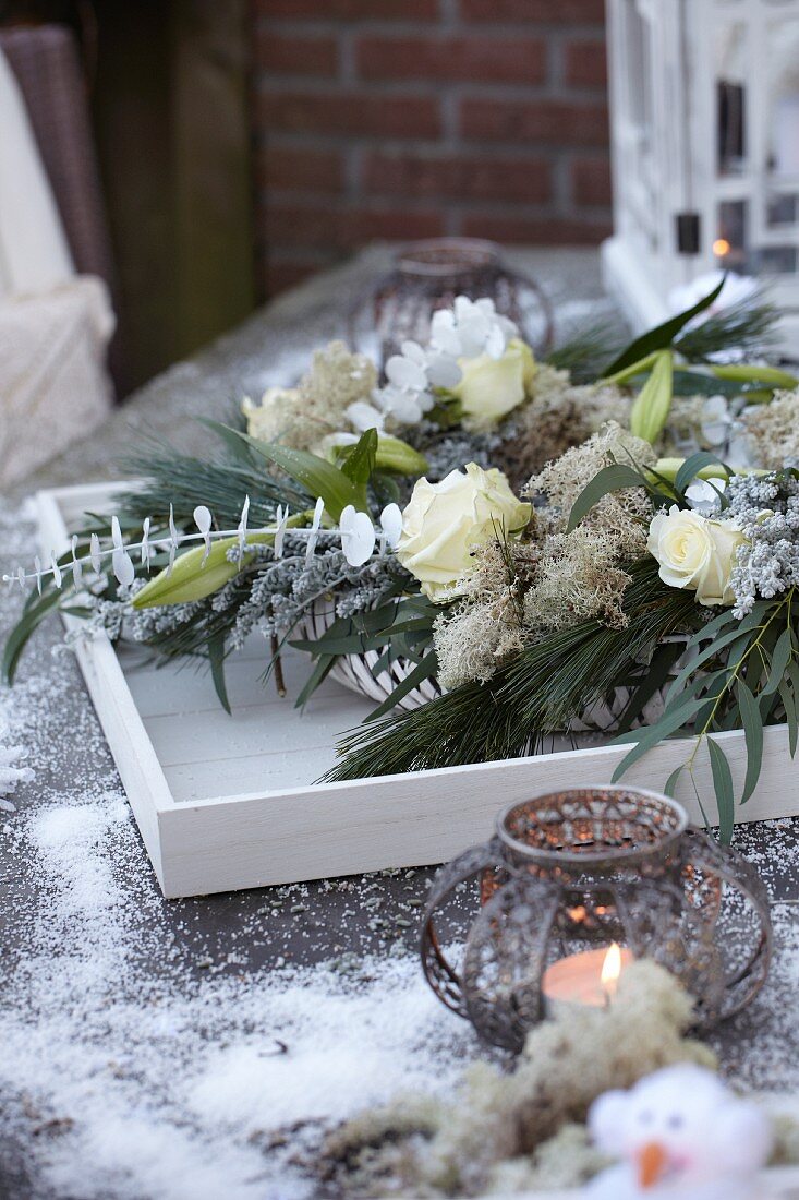Flower arrangement in wintry colours with tealight