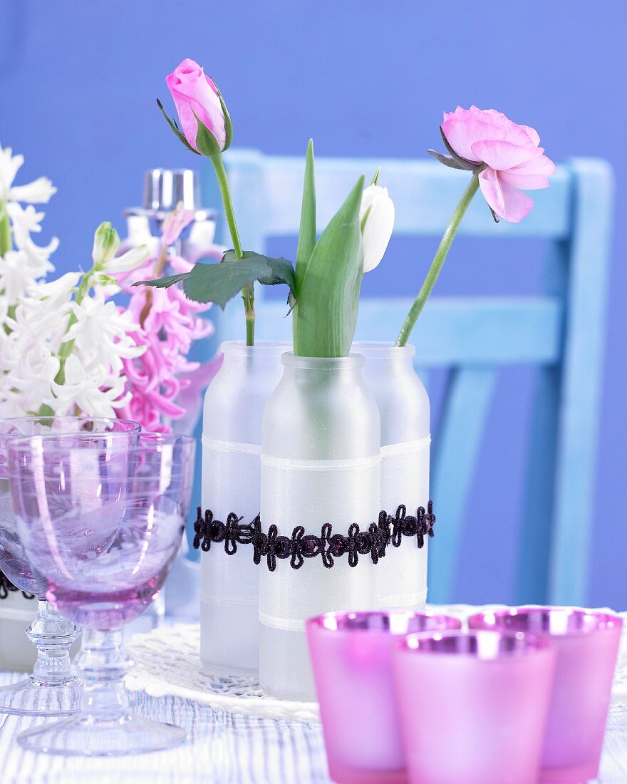 Frühlingsblumen in Vasen und im Glas