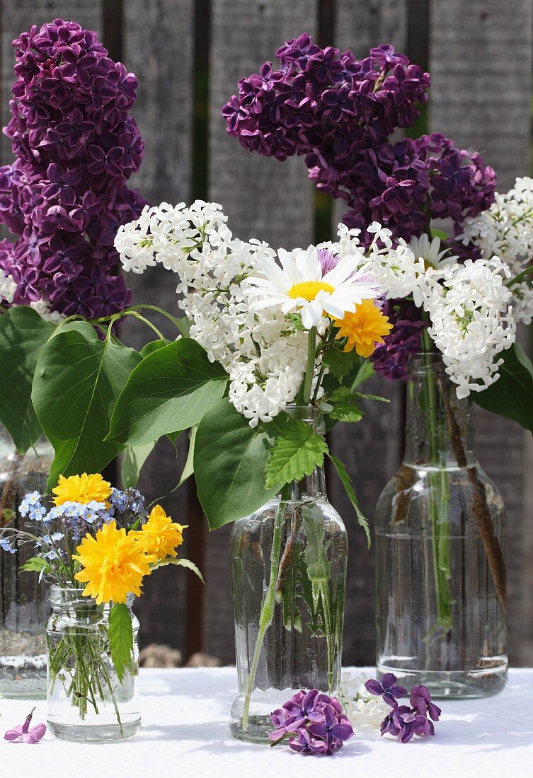 Fliederzweige & Sommerblumen in Glasflaschen