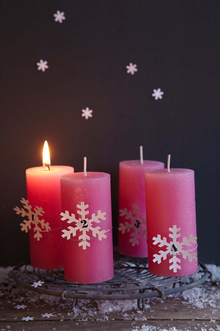 Group of candles with Christmas decorations on trivet