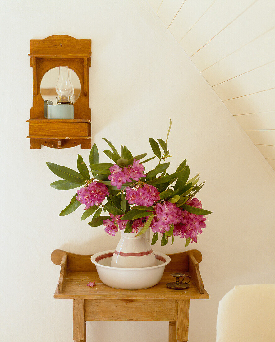 Wooden side table with wash bowl and rhododendron flowers