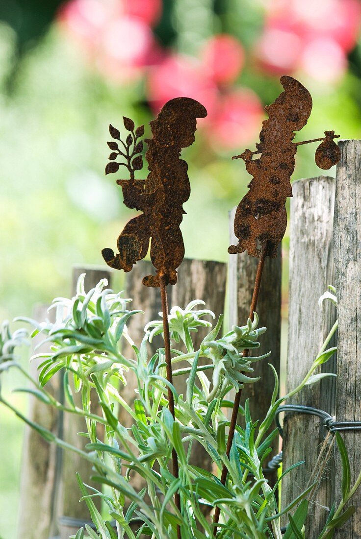 Steckzwerge aus Eisen mit Patina am Gartenzaun