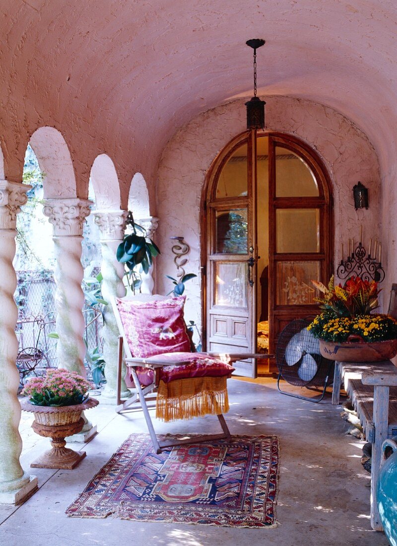 Pink limestone arcade decorated with exotic pieces in front of arched double doors