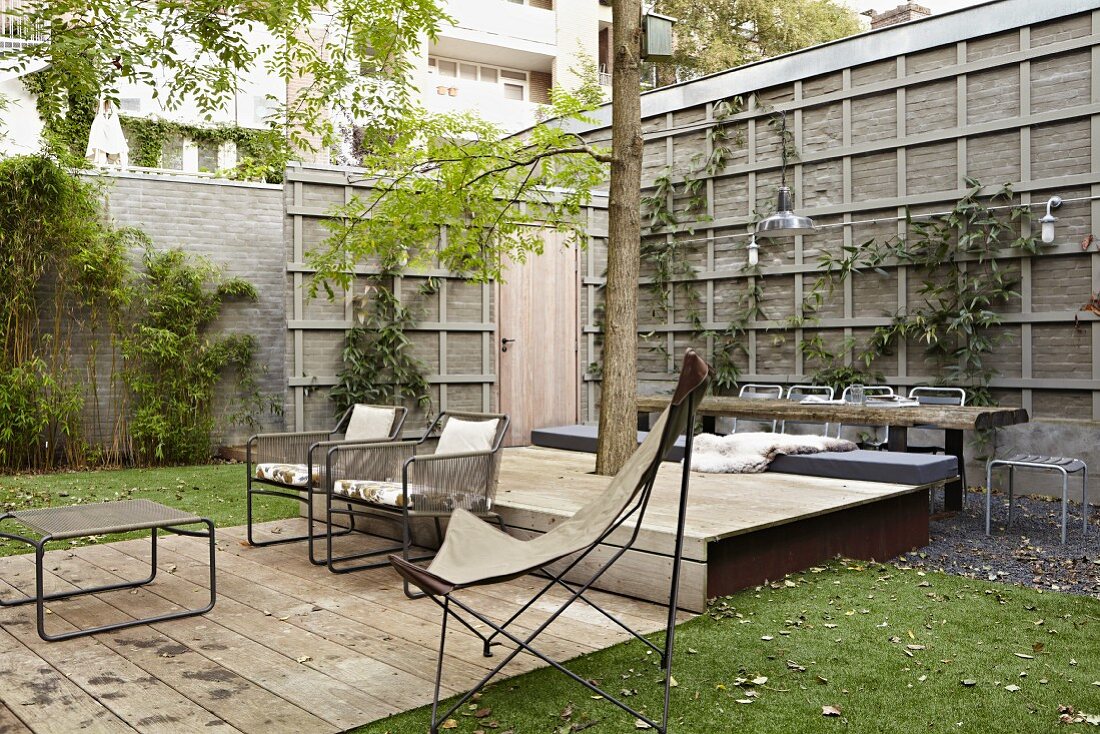 Seating area on terrace with wooden decking and butterfly chair in urban garden