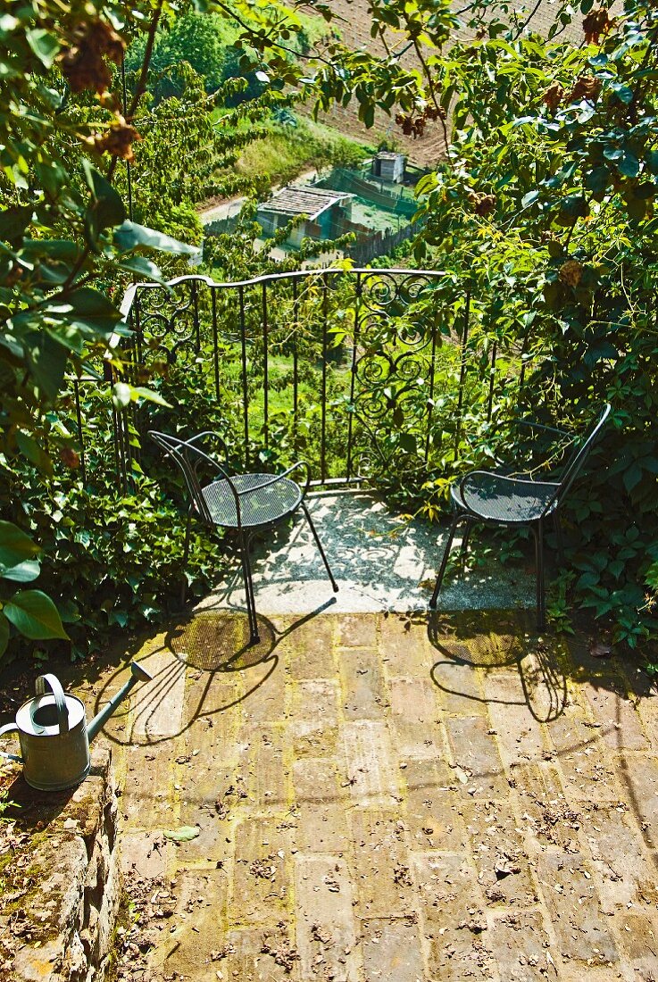 Kleiner Balkon mit zwei Stühlen und Blick in den Garten
