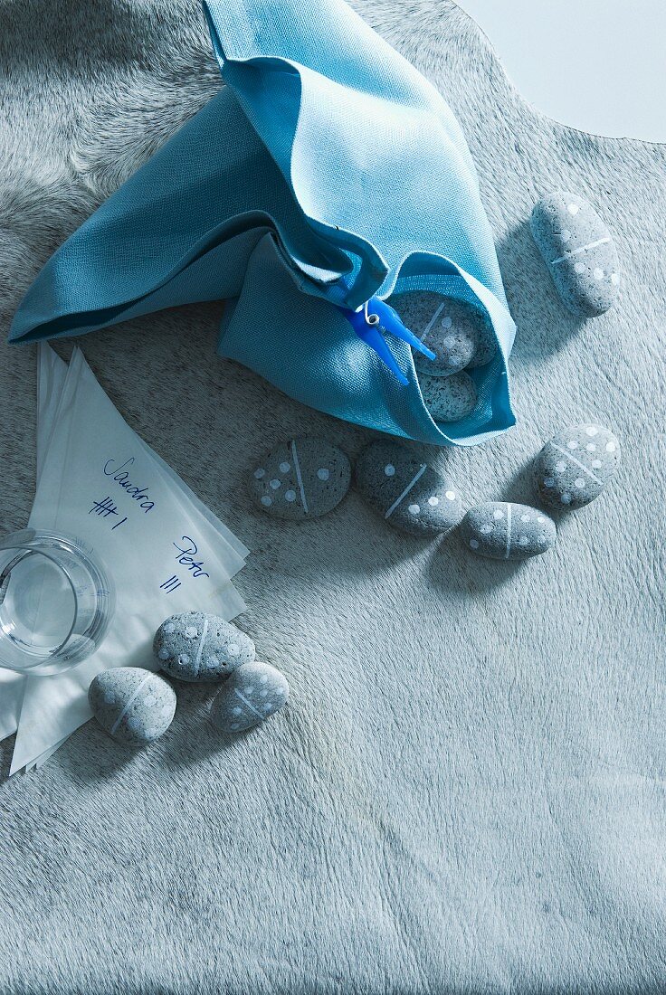 Dominosteine, teilweise in ein blaues Tuch gewickelt, und Spielstand auf Papierservietten auf einem Fell